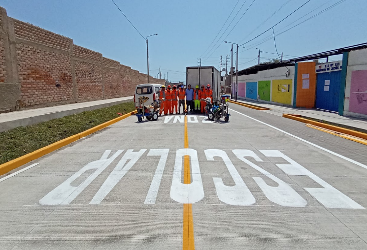 Equipo de demarcación vial pintando zona escolar en Moche
